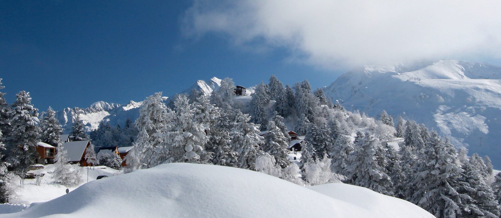 Chalets et sapins givrés sous la neige fraîche à Guzet, dans les Pyrénées ariégeoises