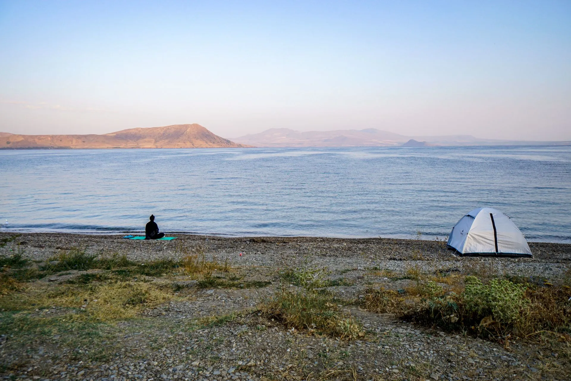 Tente dressée sur une plage au coucher du soleil