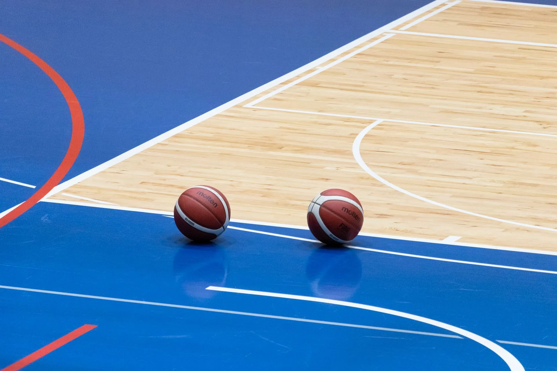Deux ballons de basket posés sur un parquet aux couleurs NBA