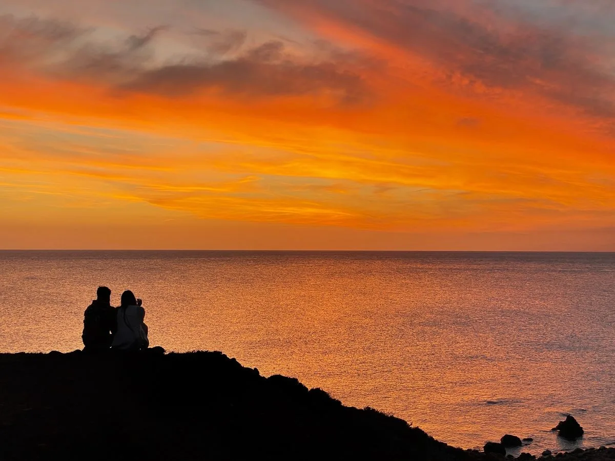Couple face au coucher de soleil sur la côte basque