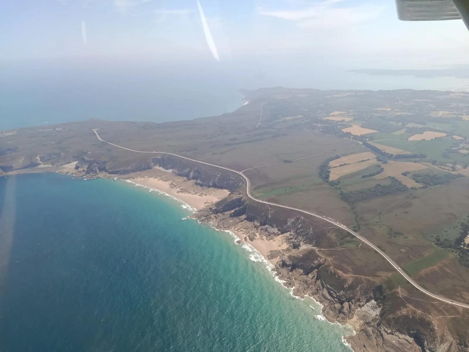 Longue plage et falaises de la Côte d'Émeraude vues du ciel en ULM