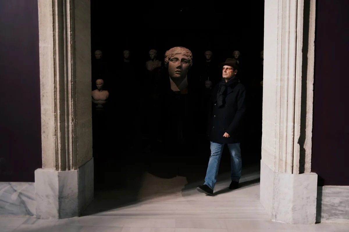 Visiteurs déambulant dans les salles d'un musée aux décors travaillés