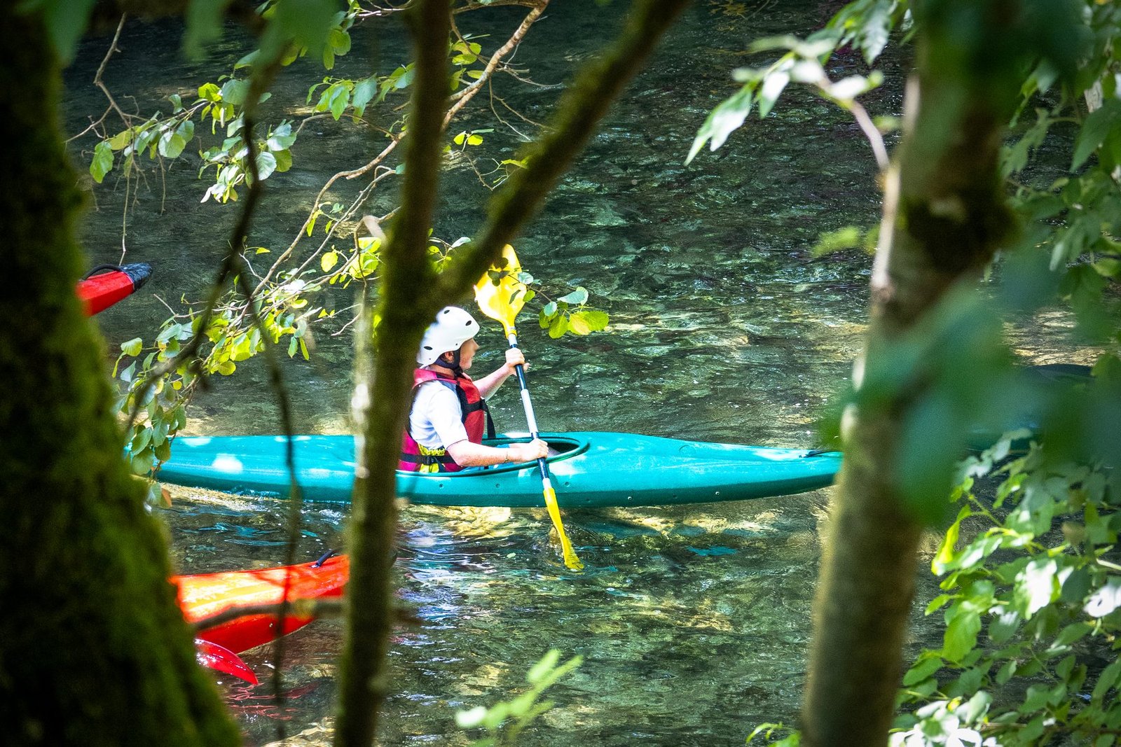 Kayakiste sur le Loup, entre les arbres des berges