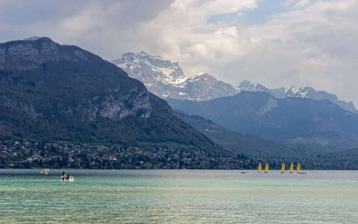 Doussard, le bout du lac d&rsquo;Annecy comme on l&rsquo;aime : plage de sable, eau turquoise et ciel plein de voiles