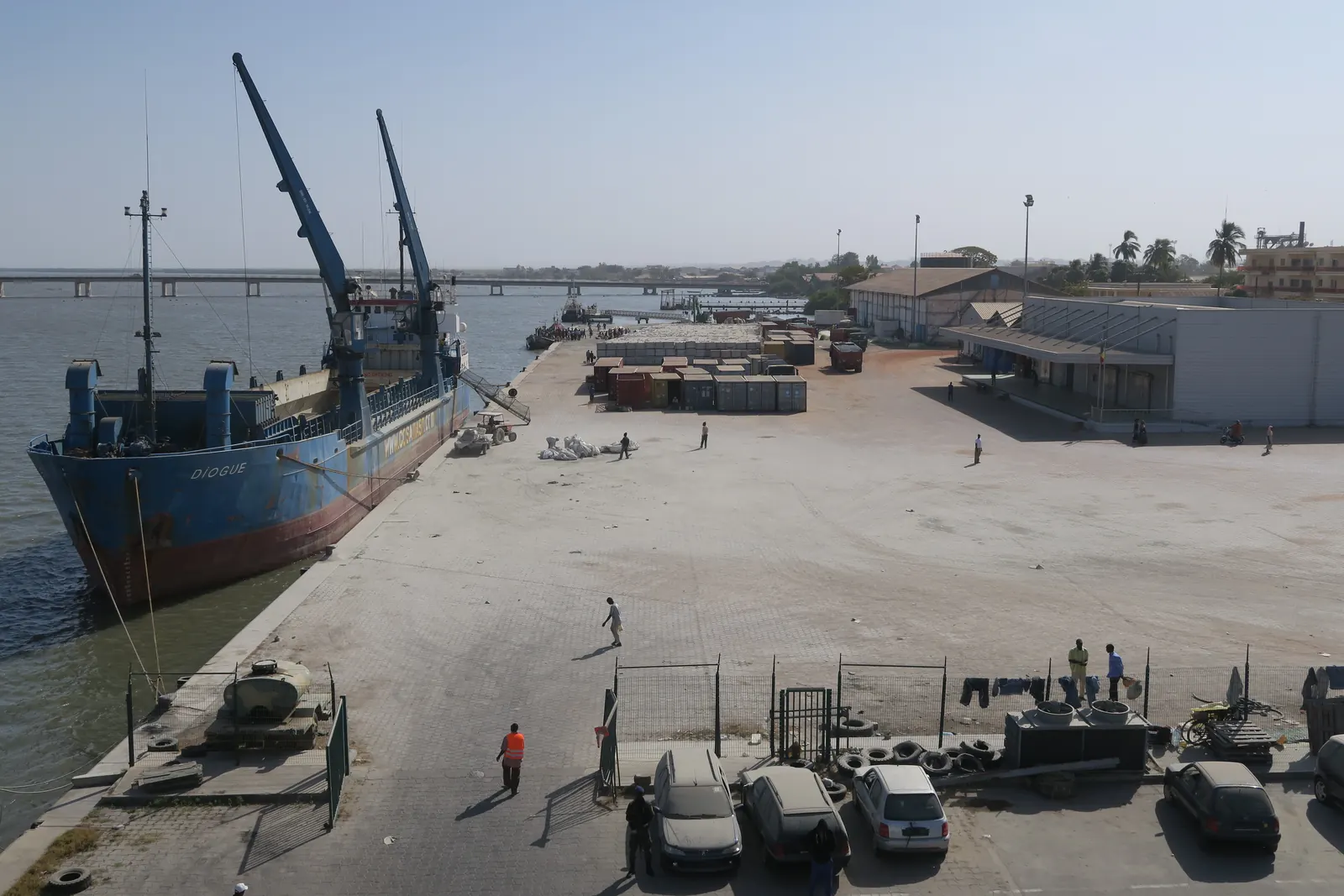 Le port de Ziguinchor sur le fleuve Casamance, avec un cargo à quai et des entrepôts