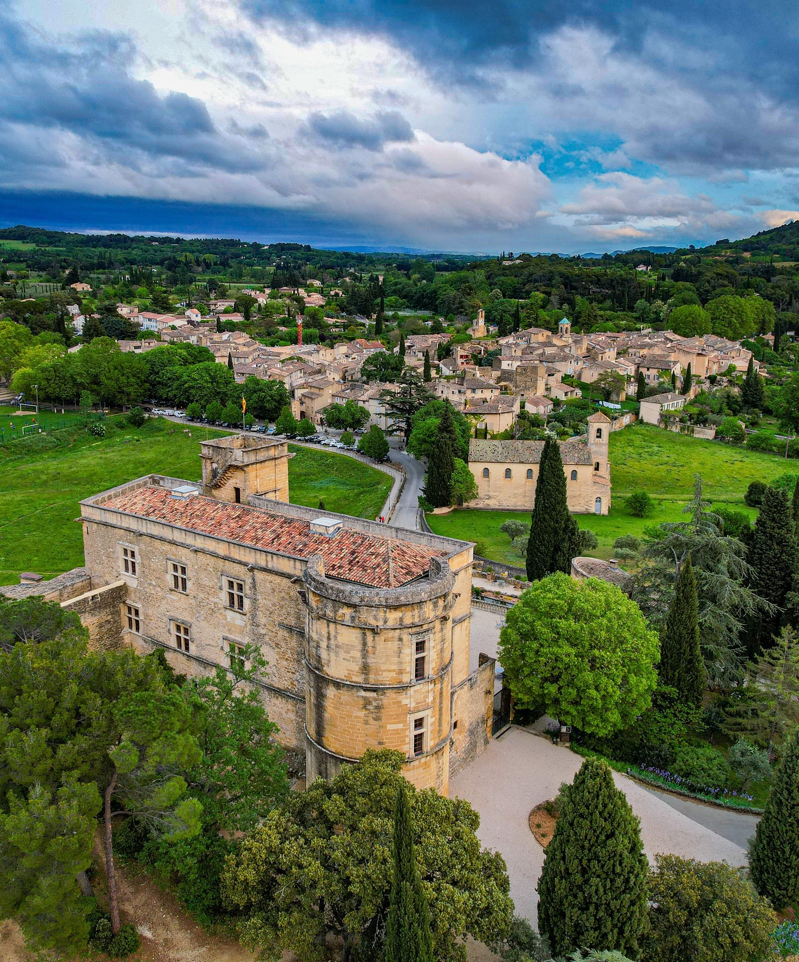 Le château de Lourmarin au premier plan, le village et le Luberon derrière