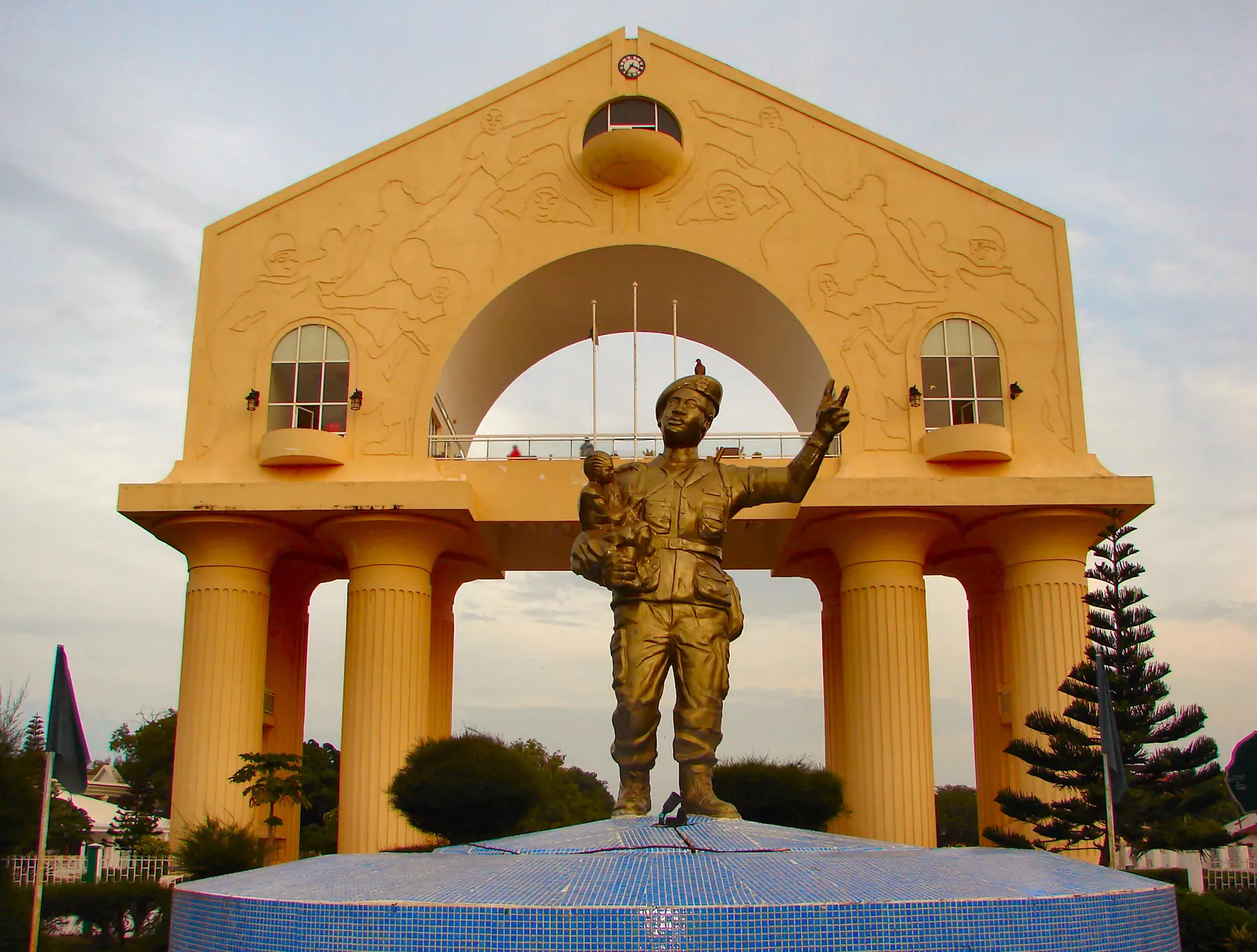 L'Arch 22, arc monumental jaune de Banjul, et la statue du soldat devant