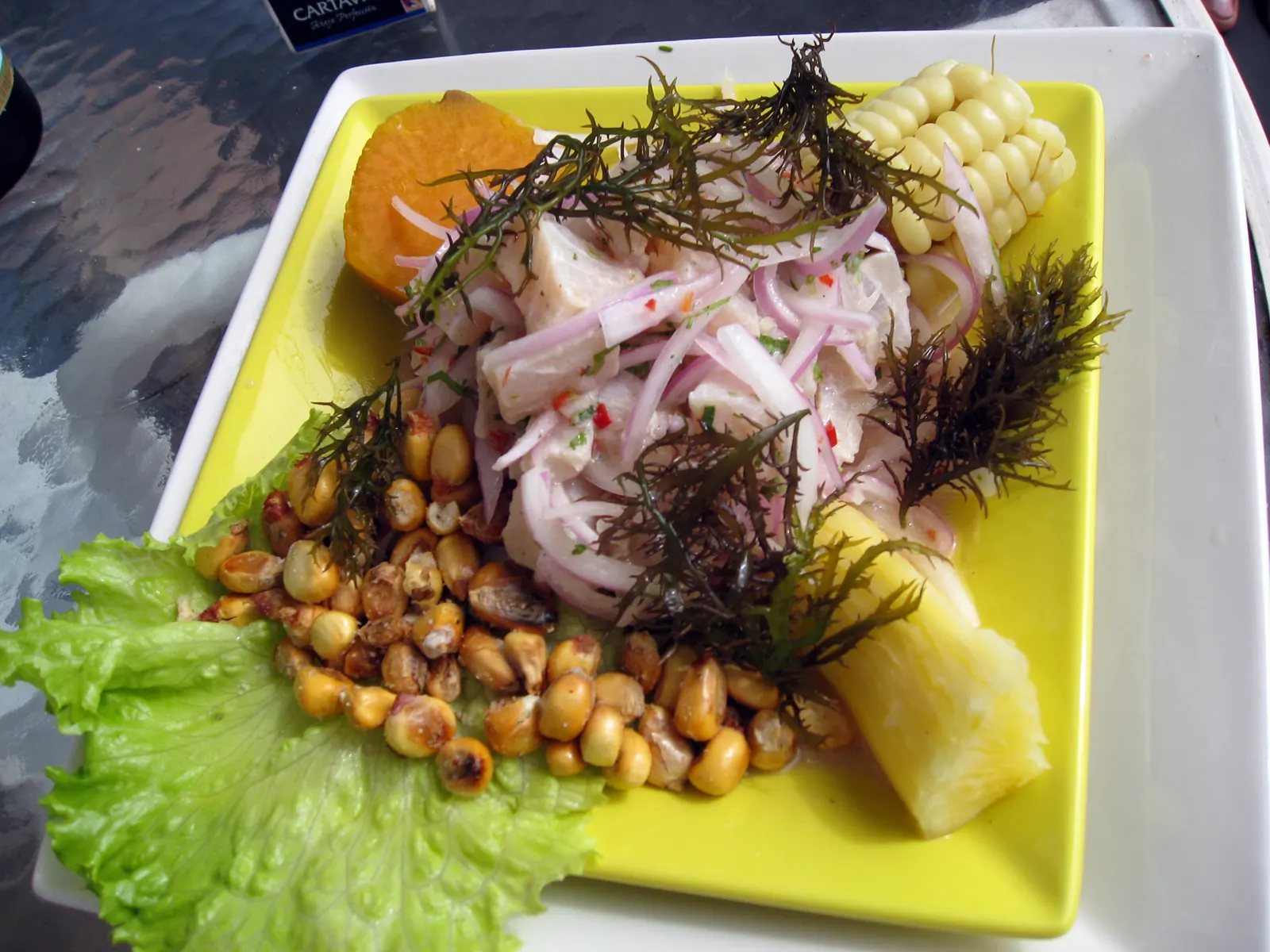 Une assiette de ceviche de poisson servie avec patate douce, maïs grillé et oignons rouges, à La Punta près de Lima