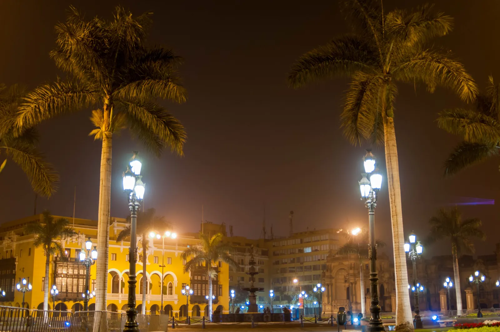 La Plaza Mayor de Lima de nuit, avec ses palmiers, ses réverbères et les façades jaunes du centre historique