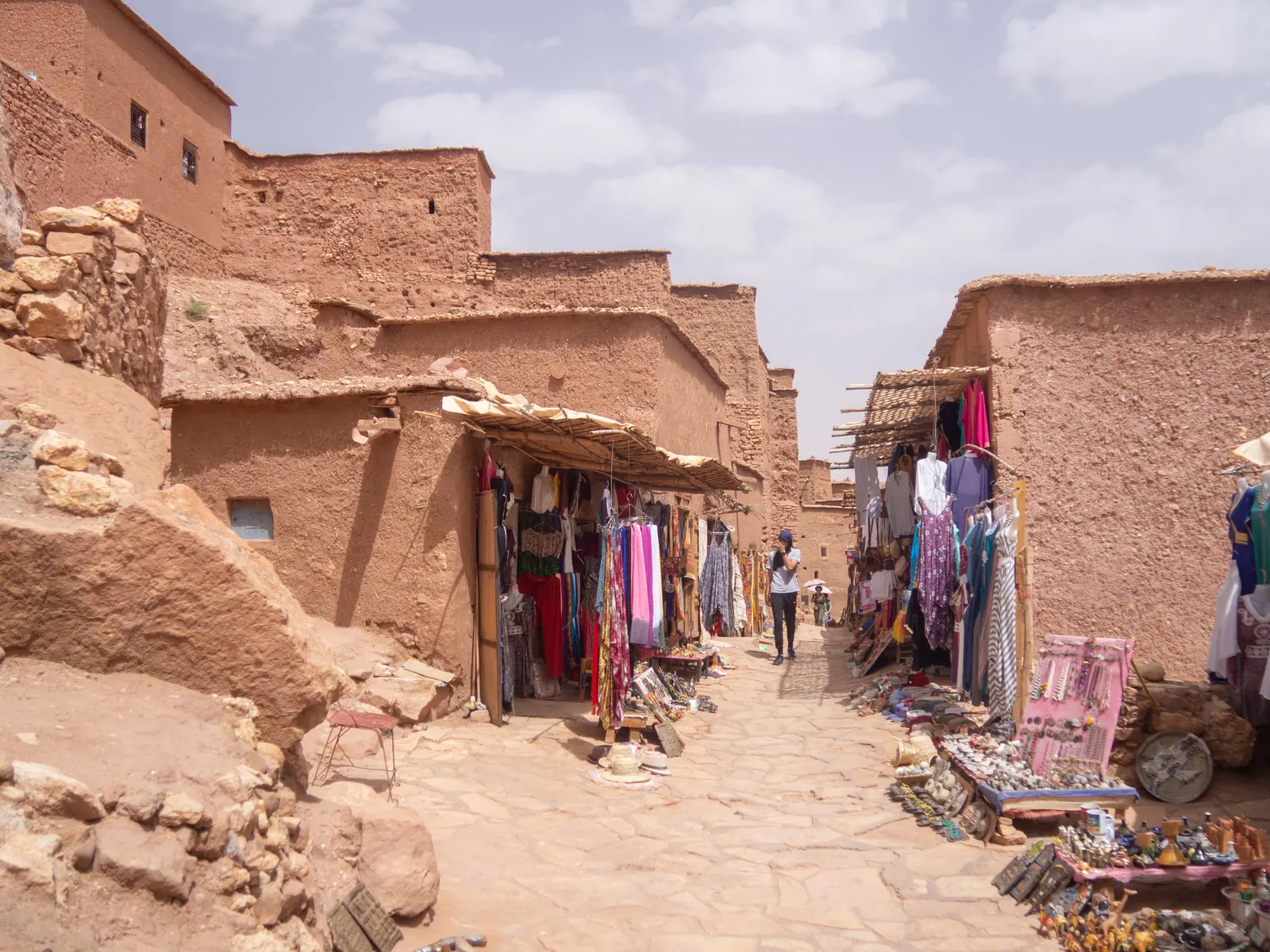 Une ruelle en terre du ksar d'Aït-Ben-Haddou bordée de boutiques de tissus et de souvenirs