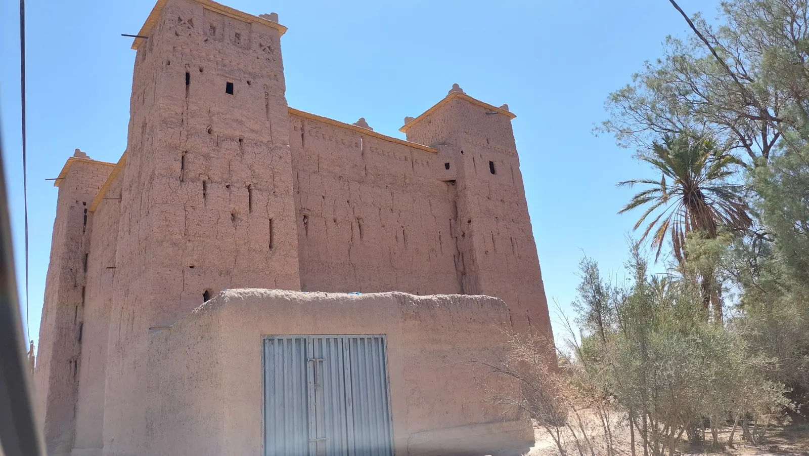 La kasbah Amridil et ses tours de pisé au milieu des arbres de la palmeraie de Skoura