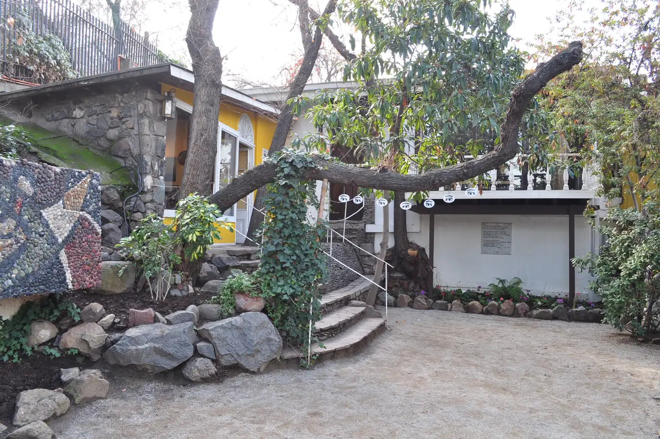 Le jardin et l'entrée de La Chascona, maison de Pablo Neruda dans le quartier Bellavista, entre rochers et arbres