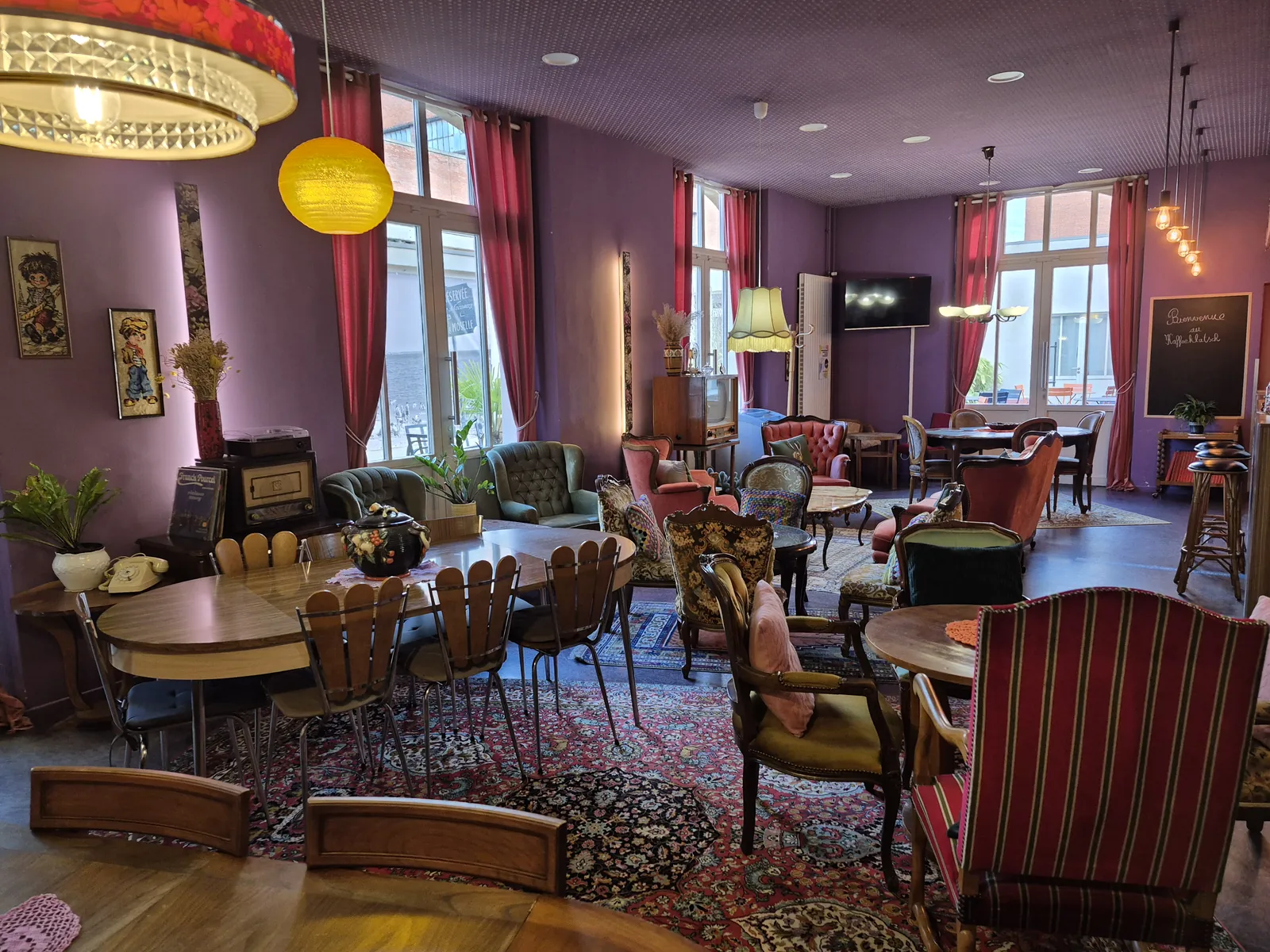 Salle du café Kaffeeklatsch au Parc Explor Wendel, mobilier dépareillé et murs violets