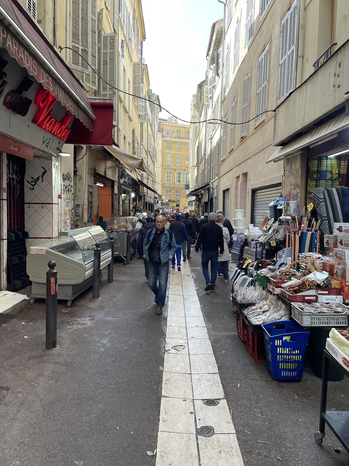 Étals d'épicerie et passants dans la rue Longue des Capucins, quartier de Noailles à Marseille