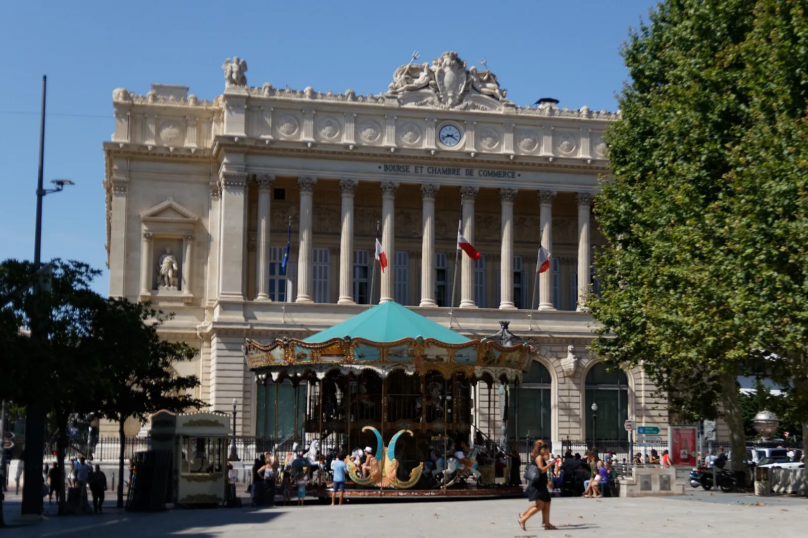 Façade néo-classique du Palais de la Bourse sur la Canebière à Marseille, avec un manège au premier plan